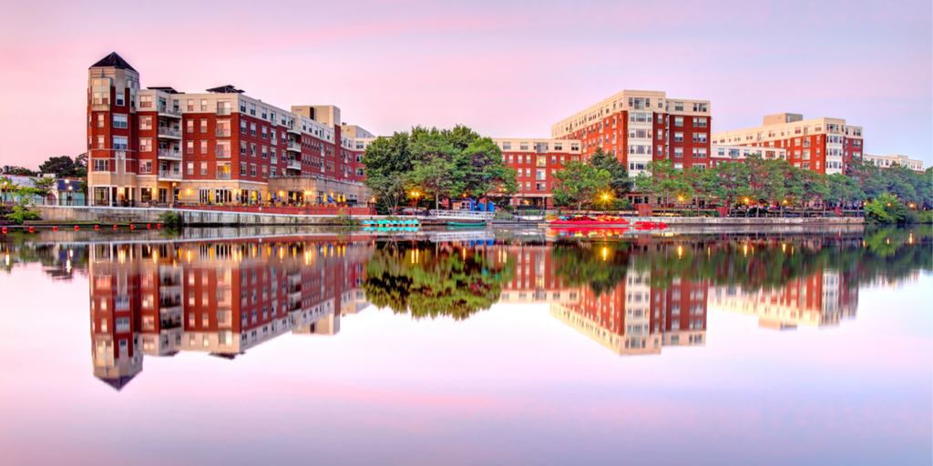 A scenic view of a city by a body of water at sunset or sunrise.