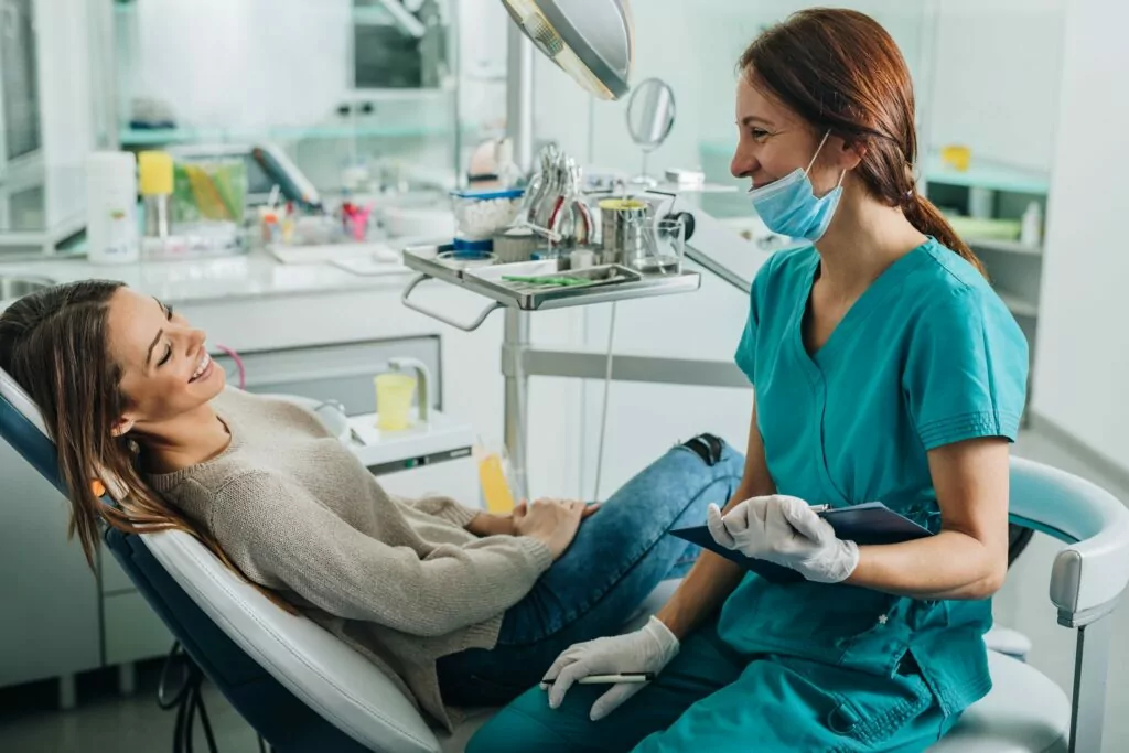 A dentist talking to a patient in a dental office.